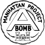 圆形的徽章，顶上书有“Manhattan Project”字样，中间是字母“A”，A下面是“BOMB”。徽章最底部是美国陆军工程兵团的城堡徽章。